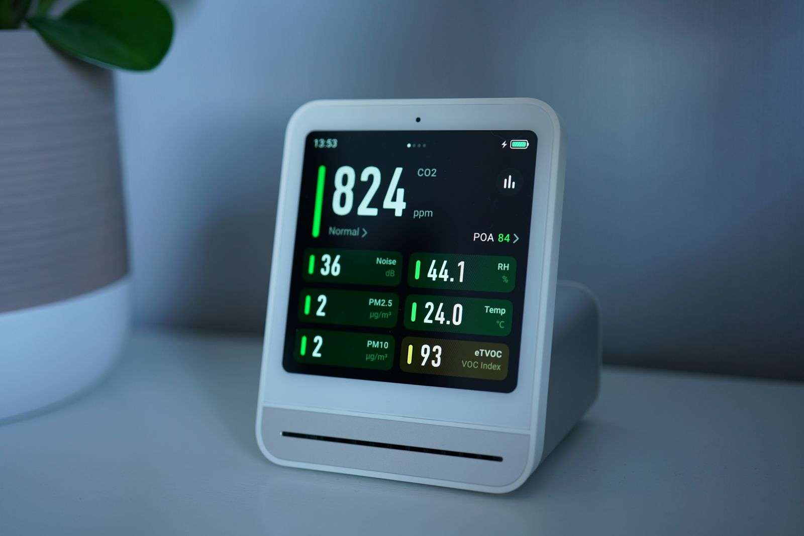 Close-up of a digital indoor air quality monitor displaying CO2, PM2.5, and temperature readings